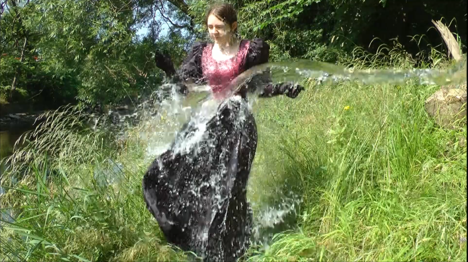  video still of Chastity in a beautiful floor length dress, taking a direct hit from a bucketful of water 